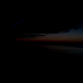 か細い月と波の音のコントラストの画像