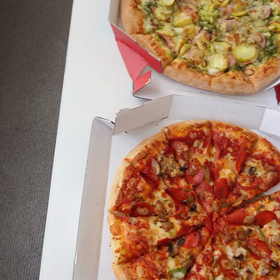 ピザに食らいつく大人たちの画像