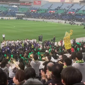 優勝の喜びを分かち合う選手と応援席の画像