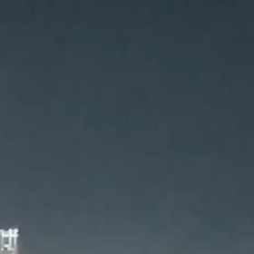 雲の中で隠れる葉巻型UFOの画像