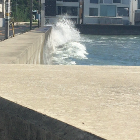 波が防波堤越えの画像