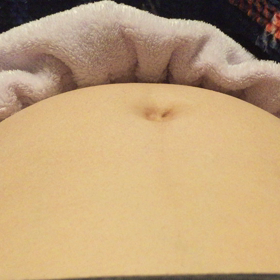 お腹の上から胎動を感じるの画像