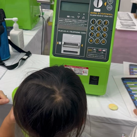 公衆電話のかけ方がわからない子供たちの画像